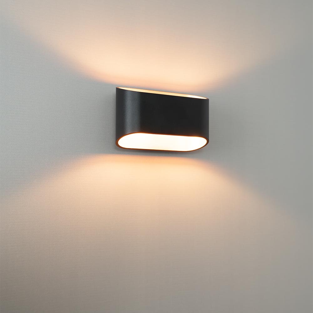 Volans nero oro - Ovalformet væglampe med op- og nedlys, matsort belægning og guldfarvet interiør